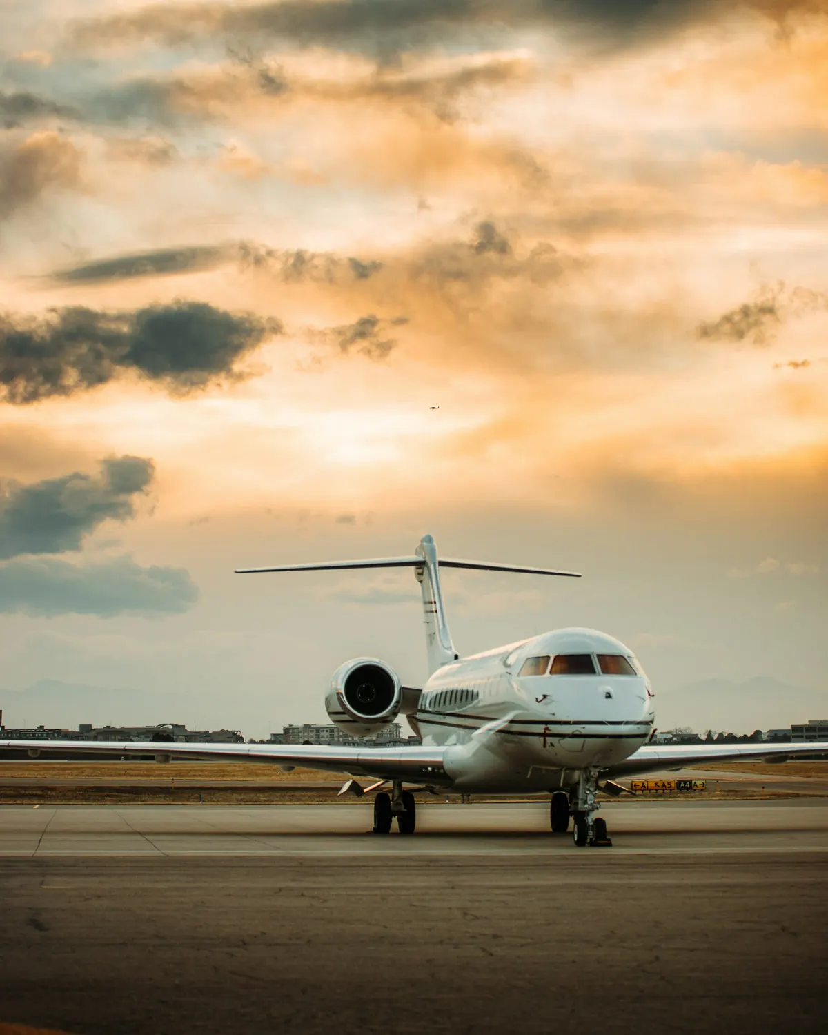 Large business jet on the apron under a golden evening sky