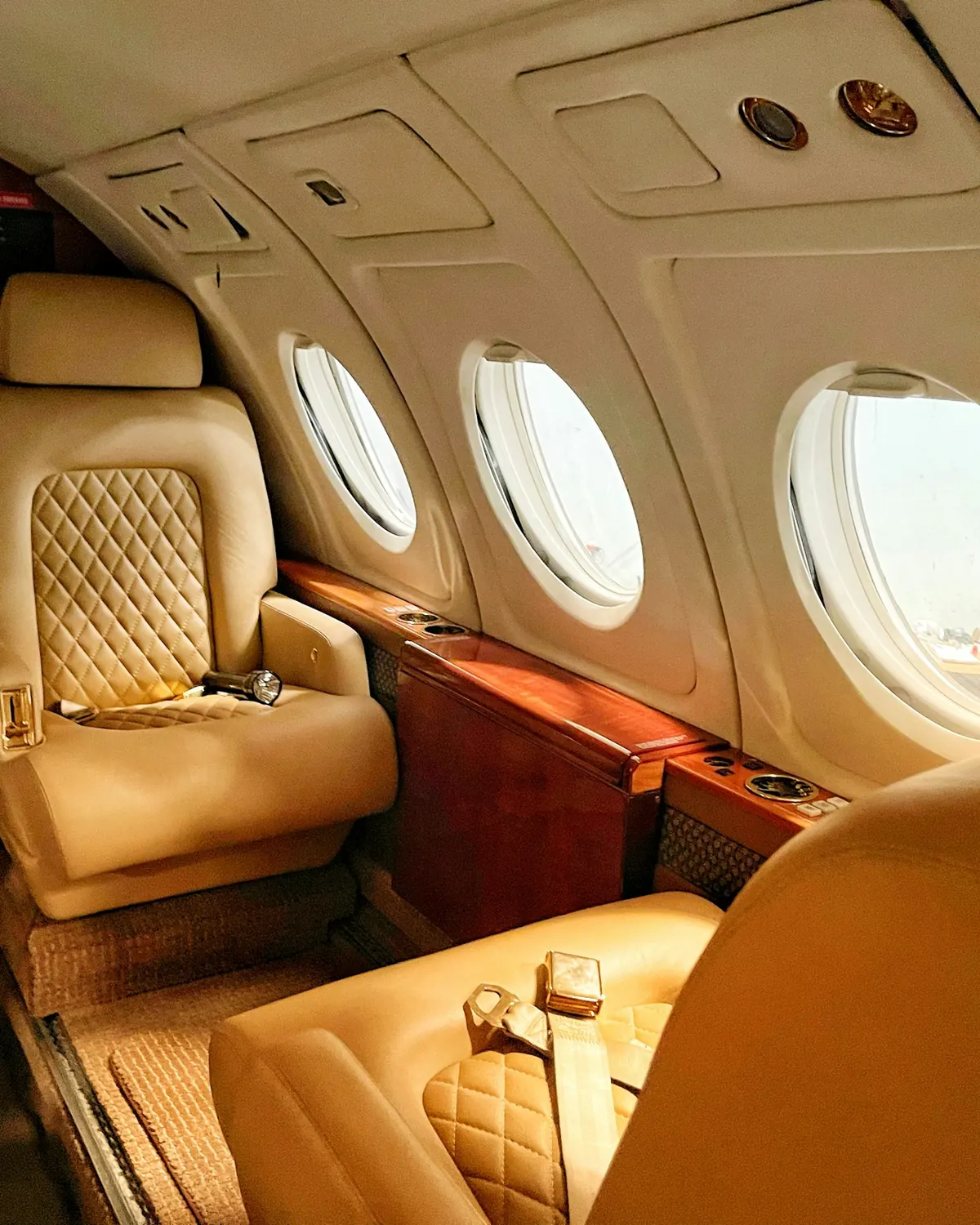 Quilted leather seats in a warmly lit jet cabin