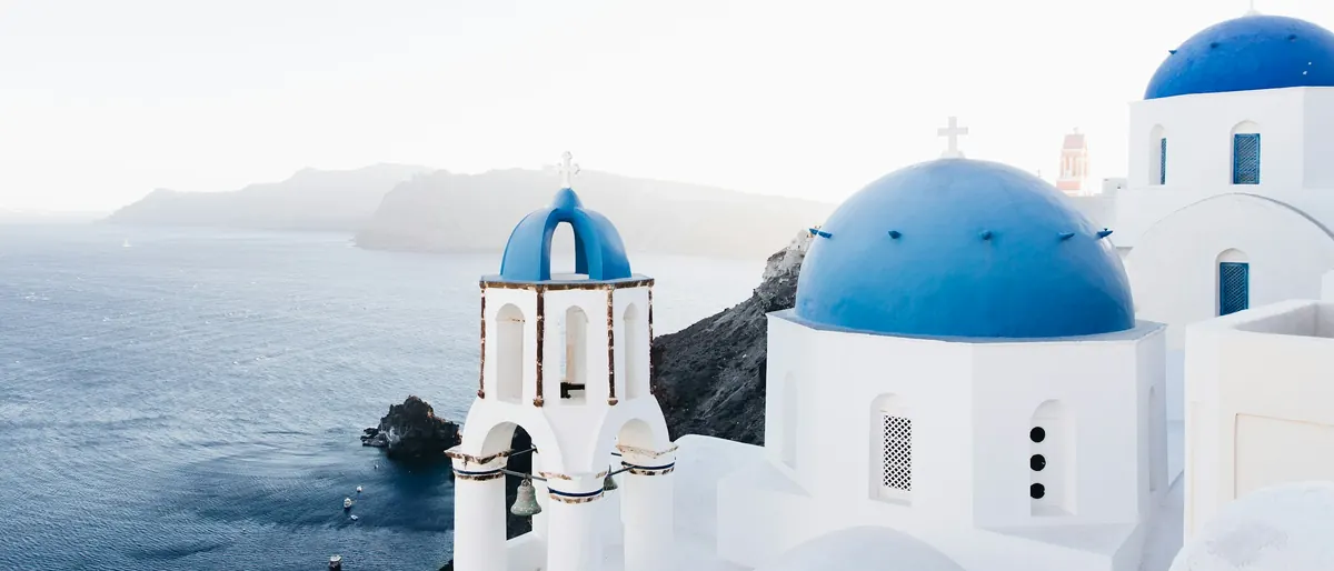 Blue-domed churches and whitewashed houses above the Aegean on Santorini