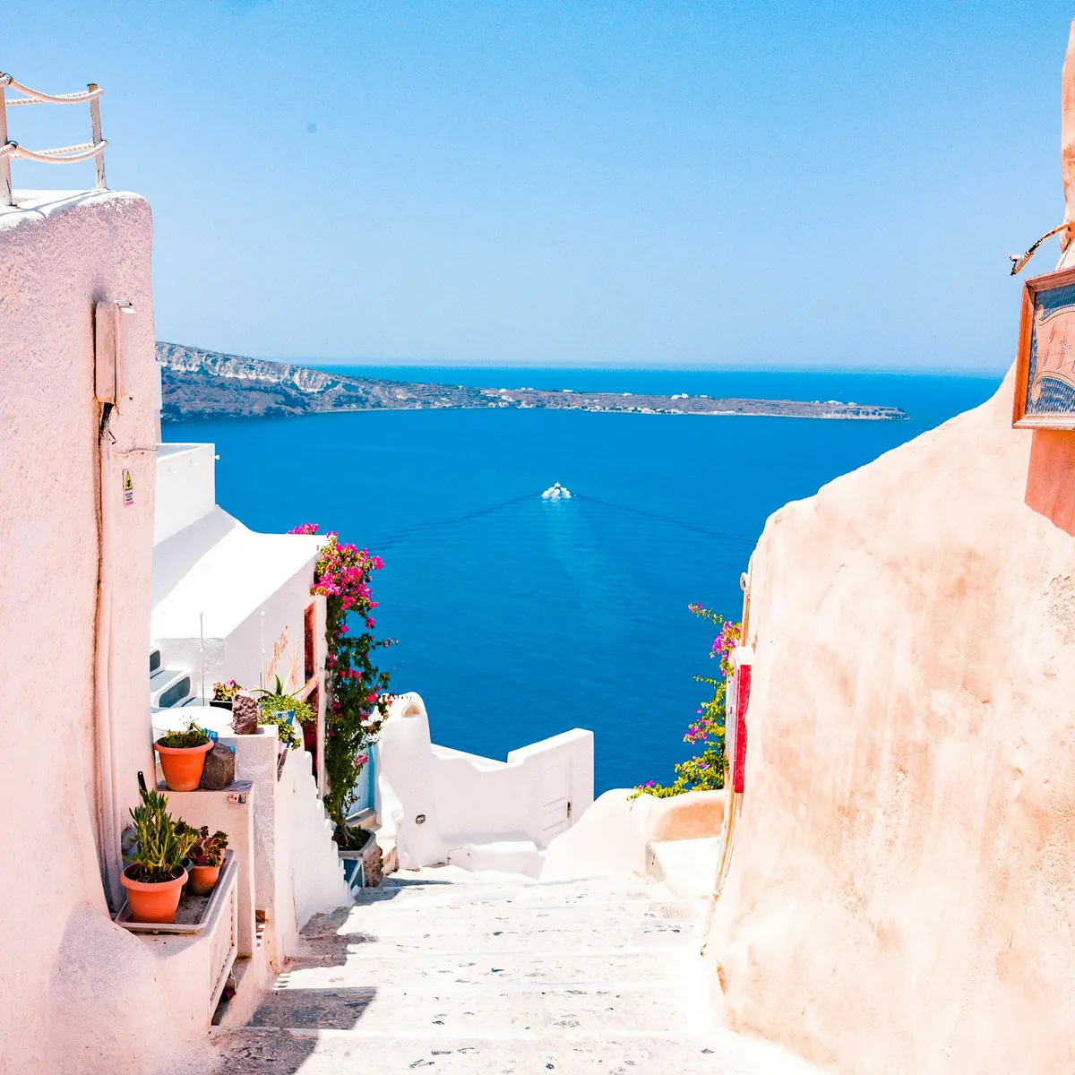 Whitewashed lane stepping down to a deep blue sea